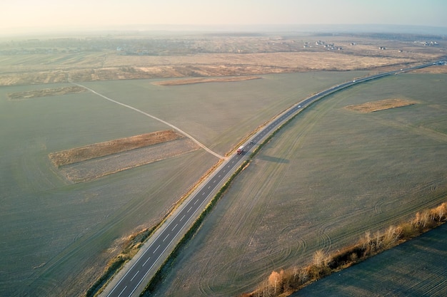 Vista aérea da estrada intermunicipal com carros rápidos ao pôr do sol. Vista superior do drone do tráfego da rodovia à noite.