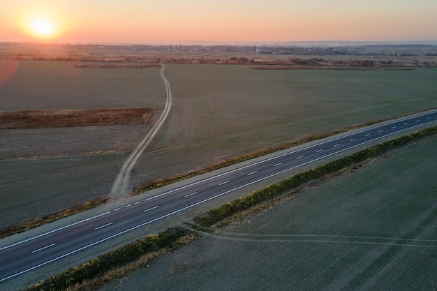 Vista aérea da estrada intermunicipal vazia com superfície de asfalto e marcações brancas à noite