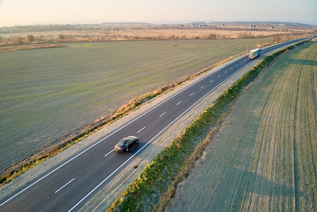 Vista aérea da estrada interurbana com carros de condução rápida ao pôr do sol Vista superior do drone do tráfego rodoviário à noite