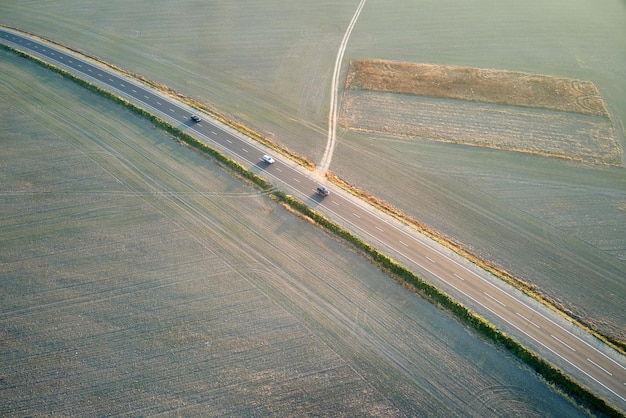 Vista aérea da estrada interurbana com carros de condução rápida ao pôr do sol Vista superior do drone do tráfego rodoviário à noite