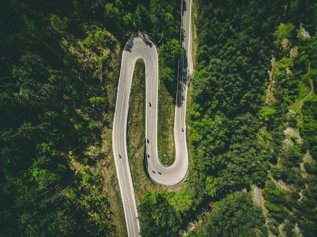 Vista aérea da estrada rural sinuosa com carros e motocicletas na Itália