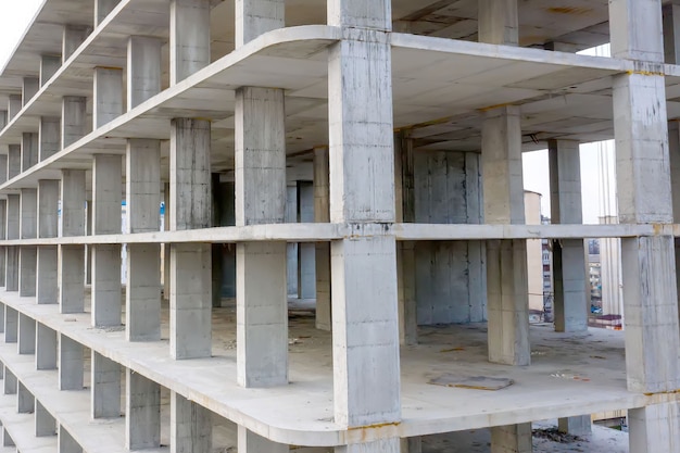 Vista aérea da estrutura de concreto de um prédio alto em construção em uma cidade.