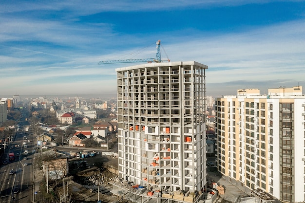 Vista aérea da estrutura de concreto de um prédio alto em construção em uma cidade.