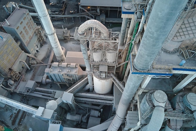 Vista aérea da fábrica de cimento com estrutura de planta de concreto alto e guindaste de torre no local de produção industrial Fabricação e conceito de indústria global