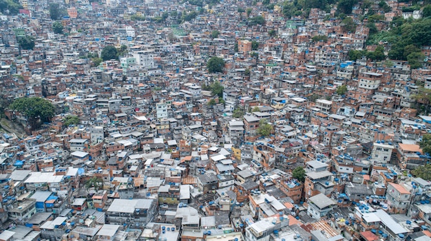 Vista aérea da Favela da Rocinha, a maior favela do Brasil nas montanhas do Rio de Janeiro e o horizonte da cidade por trás