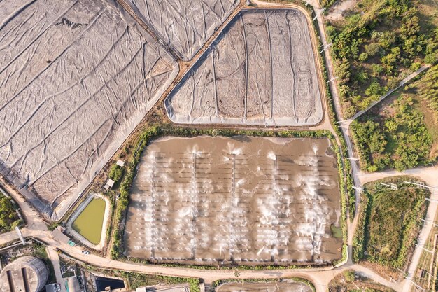 Vista aérea da grande lagoa de tratamento de águas residuais e lagoa de biomassa de fermentação coberta de plástico em usina de bioetanol de energia renovável