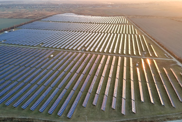 Vista aérea da grande usina elétrica sustentável com muitas fileiras de painéis solares fotovoltaicos para produzir energia elétrica limpa ao pôr do sol Eletricidade renovável com conceito de emissão zero