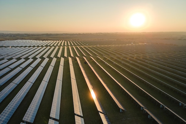 Vista aérea da grande usina elétrica sustentável com muitas fileiras de painéis solares fotovoltaicos para produzir energia elétrica limpa ao pôr do sol eletricidade renovável com conceito de emissão zero