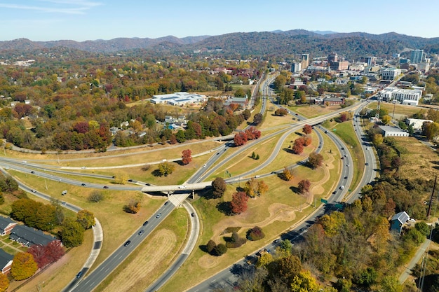 Vista aérea da interseção da autoestrada americana na temporada de outono em Asheville, Carolina do Norte, com carros e caminhões em movimento rápido Conceito de infraestrutura de transporte dos EUA