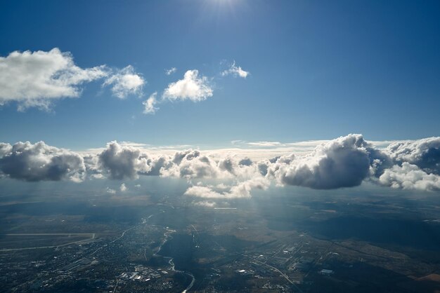 Vista aérea da janela de um avião em alta altitude da terra coberta de nuvens cumulus brancas e inchadas