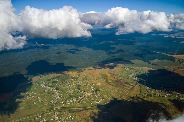 Vista aérea da janela do avião em alta altitude da terra coberta de nuvens cumulus brancas e inchadas