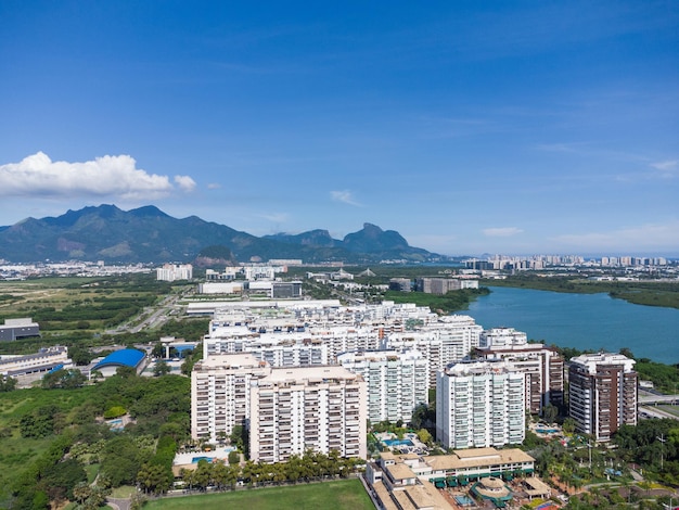 Vista aérea da lagoa de JacarÃƒÂ©paguÃ¡ no Rio de Janeiro, Brasil. Edifícios residenciais e montanhas ao redor do lago. Praia da Barra da Tijuca ao fundo. Dia ensolarado. Foto de drone.