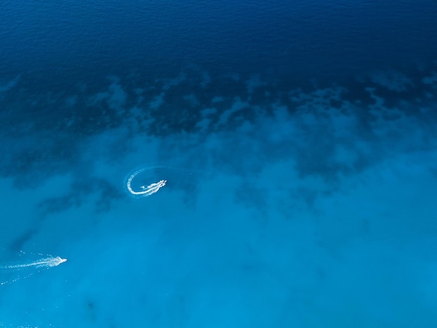 Vista aérea da lancha fazendo ondas na água do mar azul