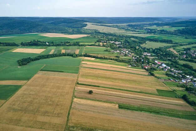 Vista aérea da paisagem de campos agrícolas cultivados verdes e amarelos com cultivos em dia de verão brilhante