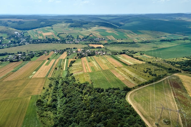 Vista aérea da paisagem de campos agrícolas cultivados verdes e amarelos com cultivos em dia de verão brilhante