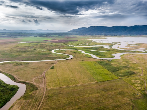 Vista aérea da paisagem do campo do rio e da bacia contra uma montanha natural