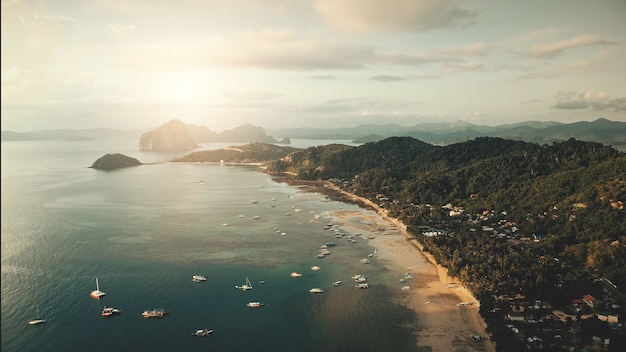 Vista aérea da paisagem urbana do cais na luz do sol. Barcos, embarcações, navios em águas rasas da baía do oceano.