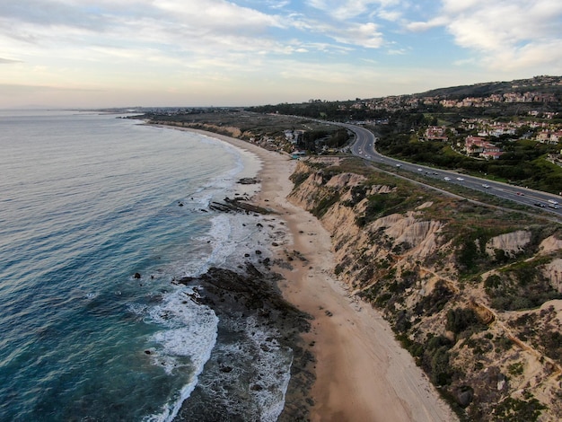 Vista aérea da pequena estrada de Newport Beach ao lado do penhasco durante o crepúsculo do pôr do sol