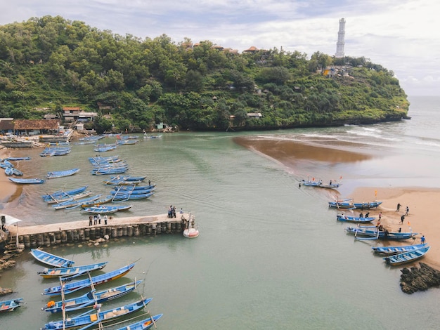 Vista aérea da praia Baron em Yogyakarta Indonésia com farol e barcos tradicionais