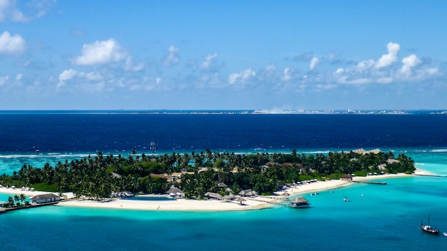 Vista aérea da praia de areia branca da ilha e da lagoa azul no resort das maldivas.