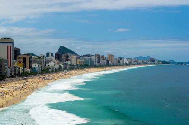 Foto vista aérea da praia do leblon no rio de janeiro no verão cheio de gente.