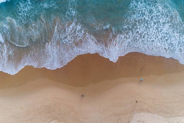 Vista aérea da praia e das ondas quebrando na costa arenosa