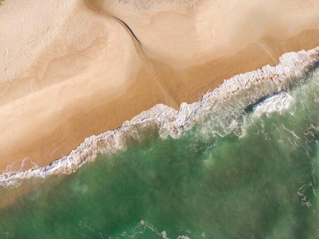 Vista aérea da Prainha, um paraíso na zona oeste do Rio de Janeiro, Brasil. Ondas e areia esverdeadas do mar. Vista do topo. Dia ensolarado ao amanhecer. Foto de drone.