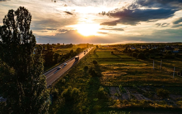 Vista aérea da rodovia intermunicipal entre árvores ao pôr do sol