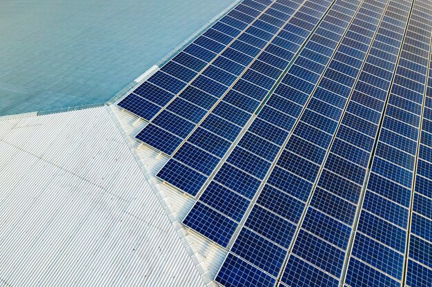 Vista aérea da superfície dos painéis solares fotovoltaicos azuis montados no telhado do prédio para a produção de eletricidade ecológica limpa. Produção do conceito de energia renovável.