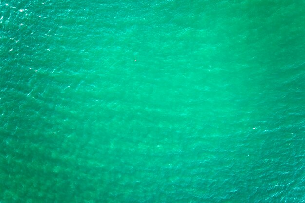 Vista aérea da superfície marinha da água do mar verde com pequenas ondas onduladas