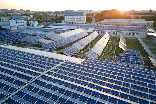 Vista aérea da usina de energia solar com painéis fotovoltaicos azuis montados no telhado do edifício industrial para produzir eletricidade ecológica verde Produção do conceito de energia sustentável