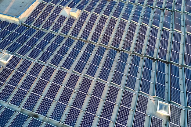 Vista aérea da usina de energia solar com painéis fotovoltaicos azuis montados no telhado do edifício industrial para produzir eletricidade ecológica verde produção do conceito de energia sustentável