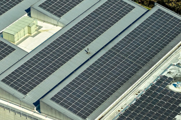 Vista aérea da usina de energia solar com painéis fotovoltaicos azuis montados no telhado do edifício industrial para produzir eletricidade ecológica verde Produção do conceito de energia sustentável