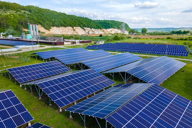 Vista aérea da usina elétrica com fileiras de painéis solares fotovoltaicos para a produção de energia elétrica ecológica limpa na área industrial. eletricidade renovável com conceito de emissão zero.