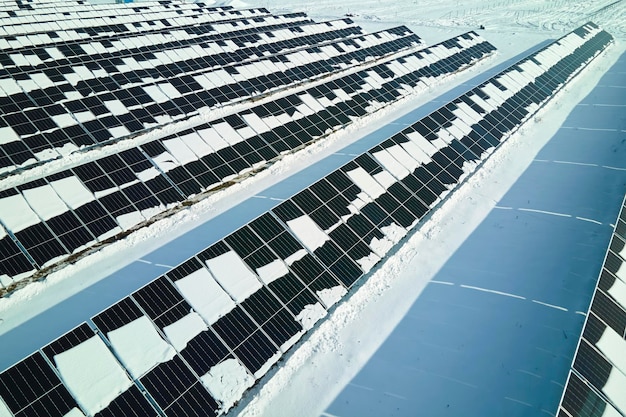 Vista aérea da usina elétrica com painéis solares cobertos de neve derretendo no final do inverno para produzir energia limpa Conceito de baixa efetividade de eletricidade renovável na região norte