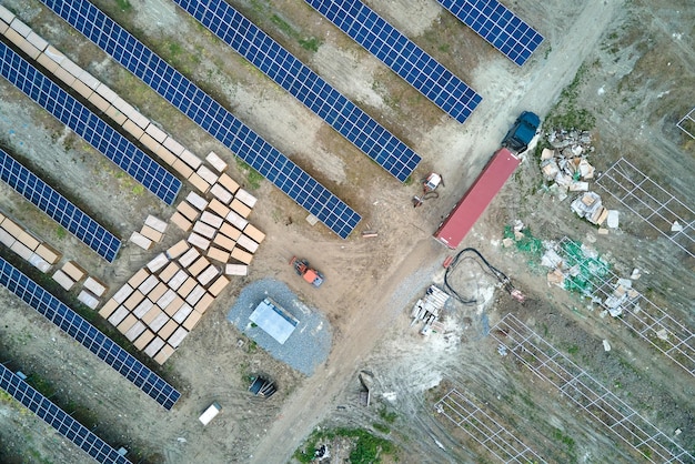 Vista aérea da usina elétrica em construção com caminhão entregando peças de montagem para painéis solares em estrutura metálica para produção de energia elétrica Desenvolvimento de eletricidade renovável