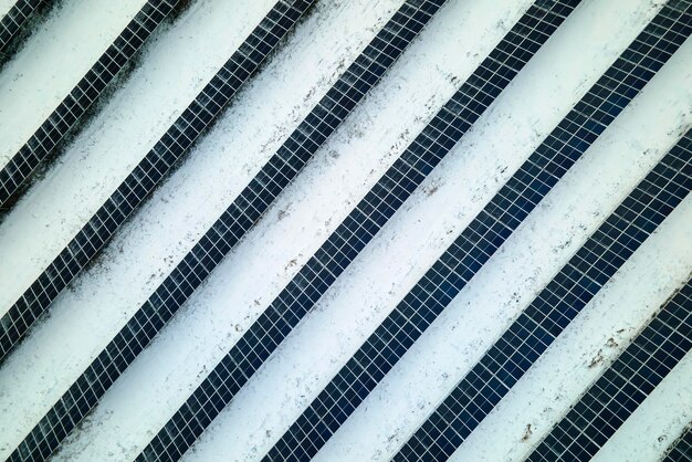 Vista aérea da usina elétrica sustentável coberta de neve com fileiras de painéis solares fotovoltaicos para produzir energia elétrica limpa Baixa efetividade da eletricidade renovável no inverno do norte