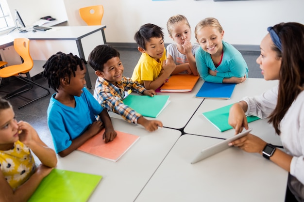 Vista aérea de alunos e professor com tablet