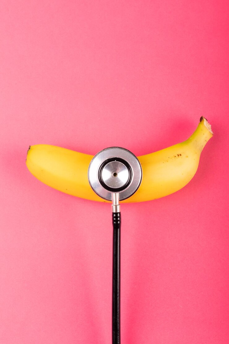 Foto vista aérea de banana fresca com estetoscópio por espaço de cópia em fundo rosa. alimentos orgânicos inalterados, alimentação saudável e conceito de equipamento médico.