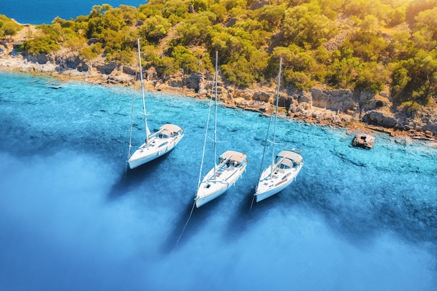 Vista aérea de belos iates e barcos no mar ao nascer do sol no verão Ilha Gemiler na Turquia Vista superior de iates de luxo veleiros água turquesa praia montanha e floresta verde Viagem