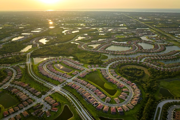 Vista aérea de casas bem compactadas na Flórida, clubes fechados com água do lago no meio Casas familiares como exemplo de desenvolvimento imobiliário nos subúrbios americanos