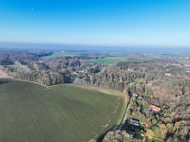 Vista aérea de casas cercadas por florestas e terras agrícolas na área rural da Valônia Bélgica