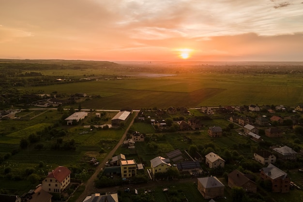 Vista aérea de casas residenciais em área rural suburbana ao pôr do sol