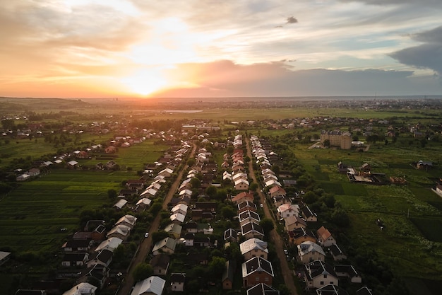 Vista aérea de casas residenciais em área rural suburbana ao pôr do sol