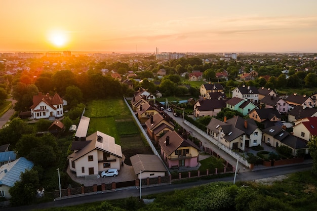 Vista aérea de casas residenciais na zona rural suburbana ao pôr do sol.