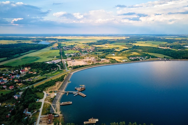 Vista aérea de cima da bela paisagem com grande lago na zona rural perto da pequena cidade no verão