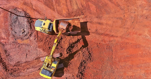 Vista aérea de cima da escavadeira trabalhando na retroescavadeira escava o solo para colocar tubos de concreto