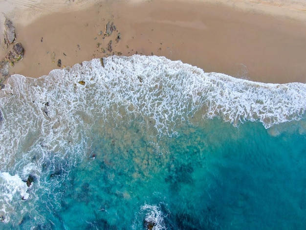 Vista aérea de cima das ondas coloridas do oceano lavando na costa do oceano pacífico califórnia