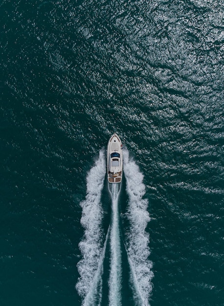 Foto vista aérea de cima para baixo do barco a motor de velocidade em mar aberto no dia de verão