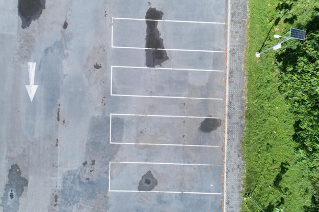 Vista aérea de cima para baixo do estacionamento vazio com uma linha branca de sinal de trânsito na rua. Acima, vista do carro em uma fileira no espaço de estacionamento Fora da área de estacionamento.